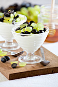 Cup of yogurt with white and black grapes