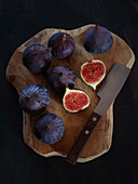 Fresh figs on a cutting board in front of a black background