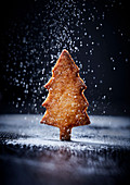 Icing sugar trickled onto fir tree biscuits