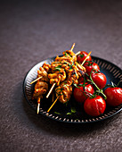 Chicken satay skewers with grilled cherry tomatoes
