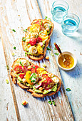 Avocado, coloured cherry tomatoes, chickpeas and mozzarella cheese on toast.