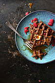 All chocolate waffles with toffee sauce and fresh raspberries