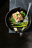 Piece of salmon on a bed of green asparagus