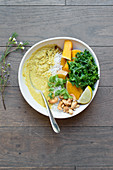 Bowl of rice with roasted squash, kale, curry cream and cashew nuts