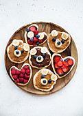 Lustig dekorierte Mini-Pancakes mit süssem Aufstrich und Früchten