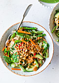 Vegetarian noodles with satay sauce, cucumber, carrots and hazelnuts