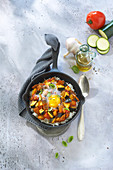 Ratatouille with cumin on a bed of rice and topped with an egg
