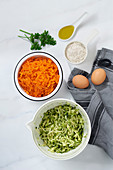 Karotten, Zucchini, Eier, Mehl und Öl als Zutaten für Gemüseröstis