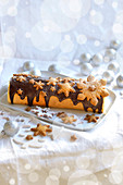 Weihnachtliche Biskuitrolle mit Schokoladenglasur und Schneeflocken-Plätzchen