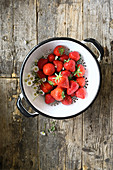 Strawberries and daisies in a colander