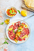 Rindercarpaccio mit Tomatensalsa, Zitronenspalten und Olivenöl