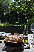 Lasagne auf gedecktem Tisch im sommerlichen Garten