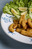 Squid fritters with lettuce and lemon slices.