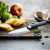 Kitchen knife on cutting board and ingredients
