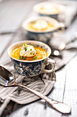 Karotten-Knollensellerie-Suppe mit Koriander serviert in Tassen
