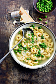 Tortellini broth with peas and parmesan