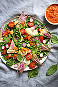 Salatplatte mit Artischocken, Erbsen und rotem Pesto