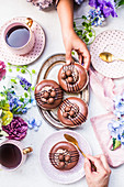 Schokoladen-Donuts dekoriert als Osternester zum Kaffee