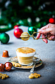 Weihnachtlicher Kaffee mit Milchschaum und Gewürzpulver
