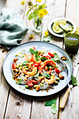 Thai salad with shrimps, rice noodles, tomatoes, basil and cashew nuts