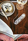 Still life with soft cheese, salami and white wine