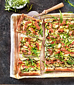Rechteckige Pizza mit Zucchini und Speck