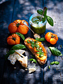 Bread topped with orange tomatoes and pesto