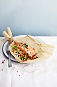 Salmon cooked in paper with butter, soy sauce and vegetables