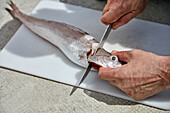 Preparing fish: Removing fish head with knife