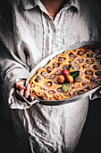 Person holding clafoutis with mirabelles