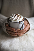 Women's hands holding vintage mug of Viennese hot chocolate