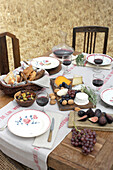 Herbstlich gedeckter Tisch mit Brot, Käse und Wein auf abgeerntetem Getreidefeld