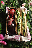 Sandwich with asparagus and cream cheese served with apple-cherry juice for a picnic