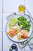 Smoked salmon waffles served with avocado and lamb's lettuce
