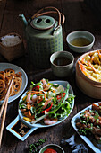 Asiatische Gerichte: Garnelensalat, Garnelenravioli, gebratenes Rindfleisch und grüner Tee