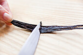 Scraping vanilla pulp from vanilla pods with a knife
