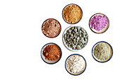 Clay in different colours in bowls on a white background