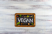 Chalk writing 'vegan' on a school blackboard
