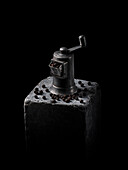 Old-fashioned pepper mill and black peppercorns
