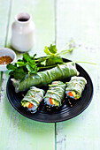 Vegetarian spring rolls with spinach sprouts, avocado, carrot, cucumber, coriander and sesame seeds