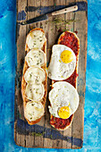 French bread with sobrasada, fried eggs, and goat cheese (Spain)