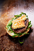 Open hamburger with ground veal, halloumi cheese, and arugula