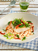 Grilled hake on white beans with herb oil