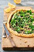 Tart with sardines, herbs, courgettes and roasted pine nuts