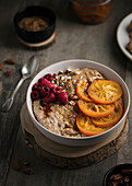 Porridge mit Mandeln, kandierten Orangen und Himbeeren