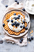 Waffles with whipped cream,blueberries and thinly sliced almonds
