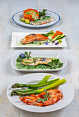 Dishes of cod, salmon, shrimp, assorted vegetables in four plates