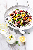 Black rice salad with salmon, cherry tomatoes, and fresh herbs in a lemon cream sauce