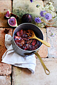 Fig compote with honey and star anise in a saucepan