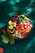 Buddha Bowl mit Quinoa, Erdbeeren, Radieschen, Zucchini, Rotkohl und Auberginen